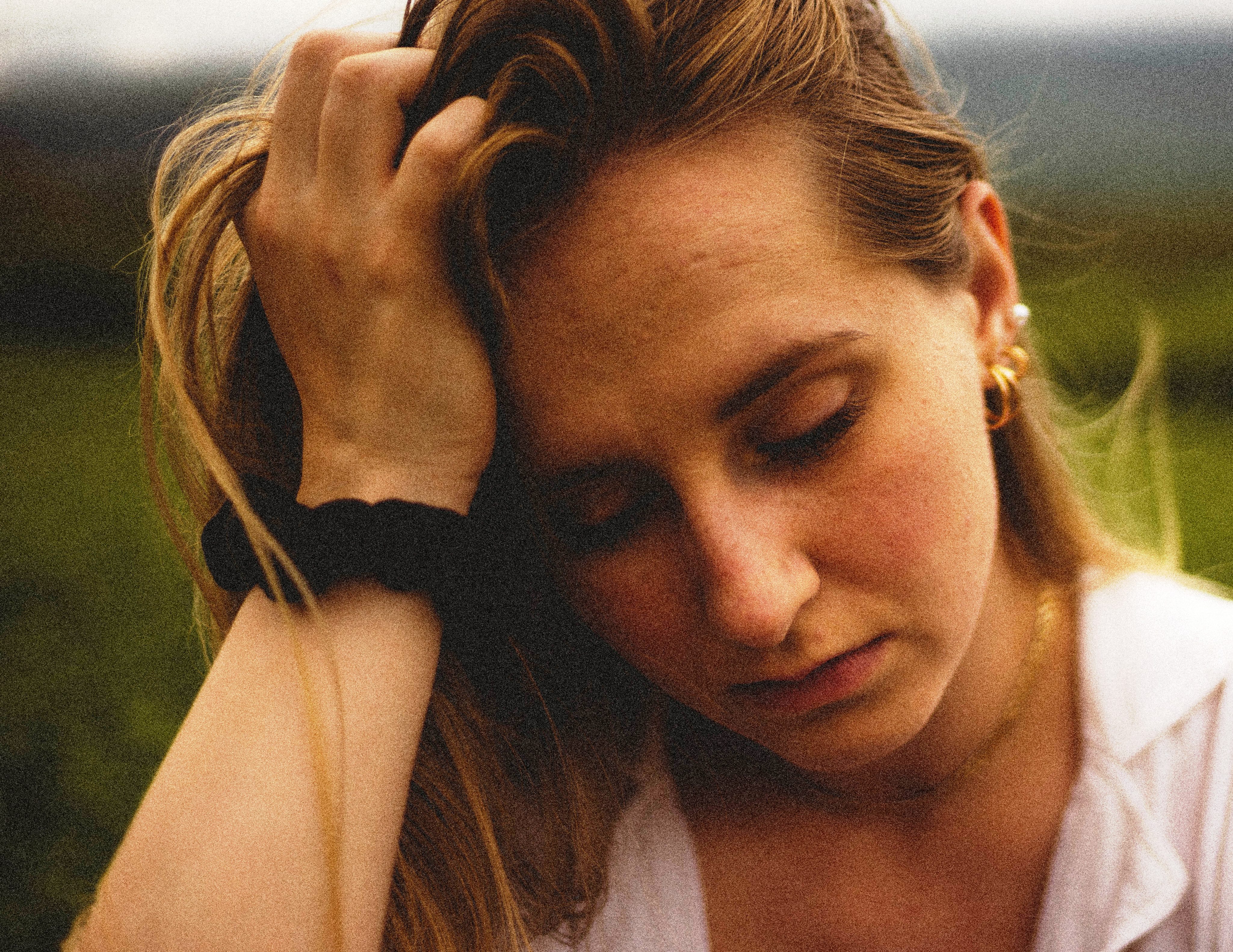 Young woman holding her head in her hands.