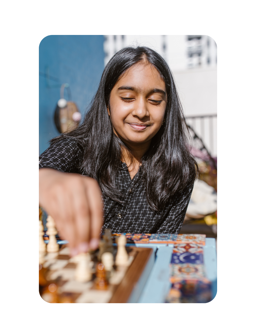 Girl playing chess and smiling.