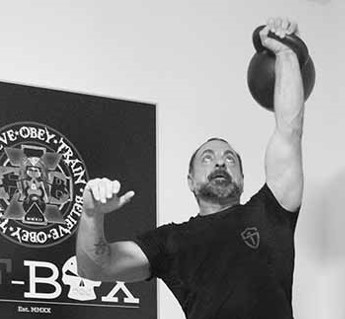 Fabio demonstrating how to press a heavy kettlebell