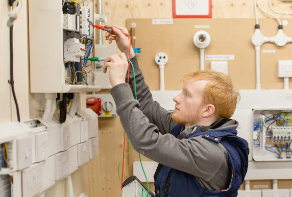 A photo of an electrical installer running tests