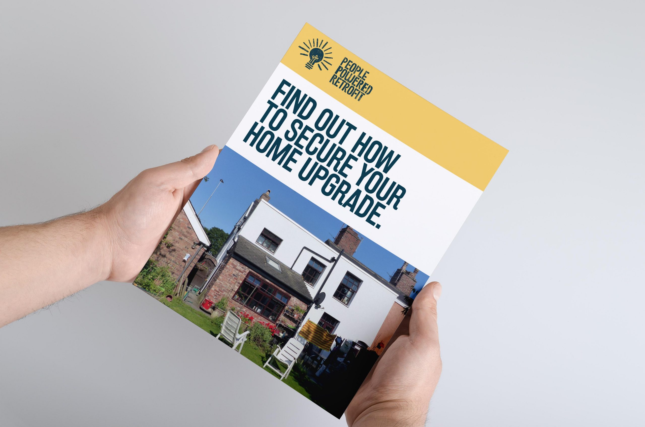 A photo of someone holding a publication called 'Find out How to Secure Your Home Upgrade'. 