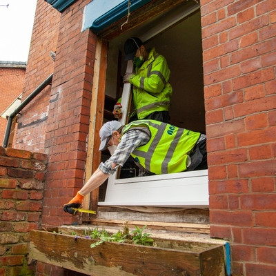 Two people in hi-vis fitting a well insulated window