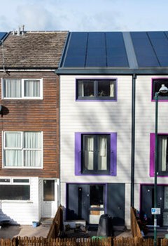 Photo of a narrow townhouse with solar panels
