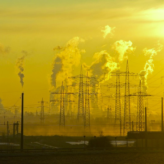 Photo of electricity pylons and industrial chimmneys. 