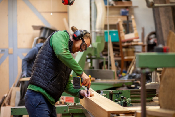 A joiner drilling a piece of wood