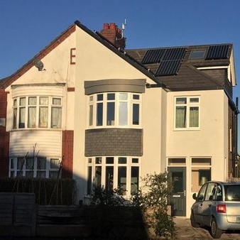 Photo of a house with external wall insulation and solar panels