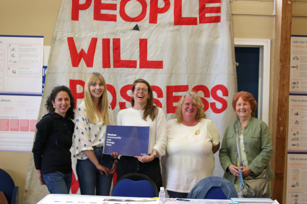 photo of carbon co-op staff and community members holding the community led energy plan