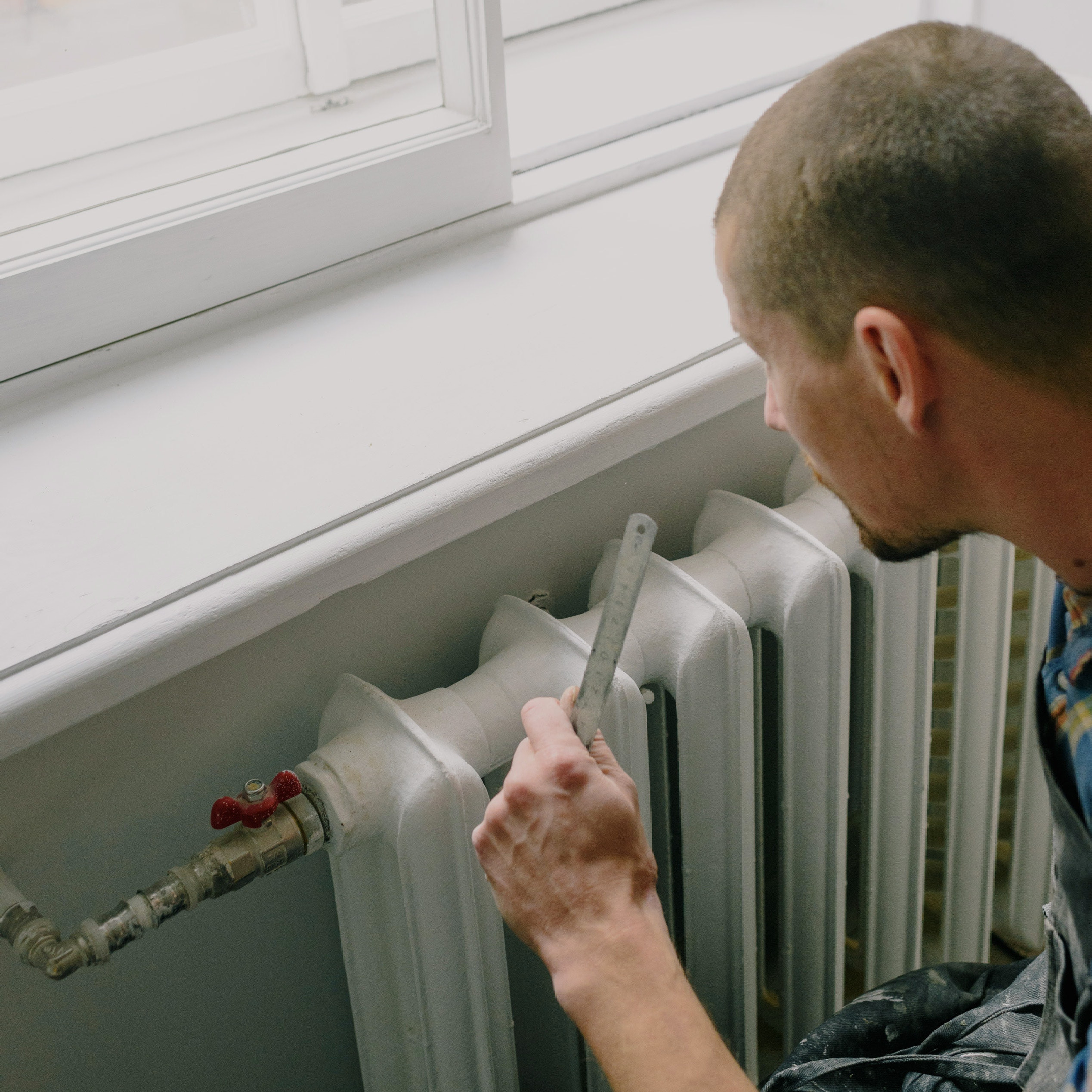 photo of a man measuring a radiator