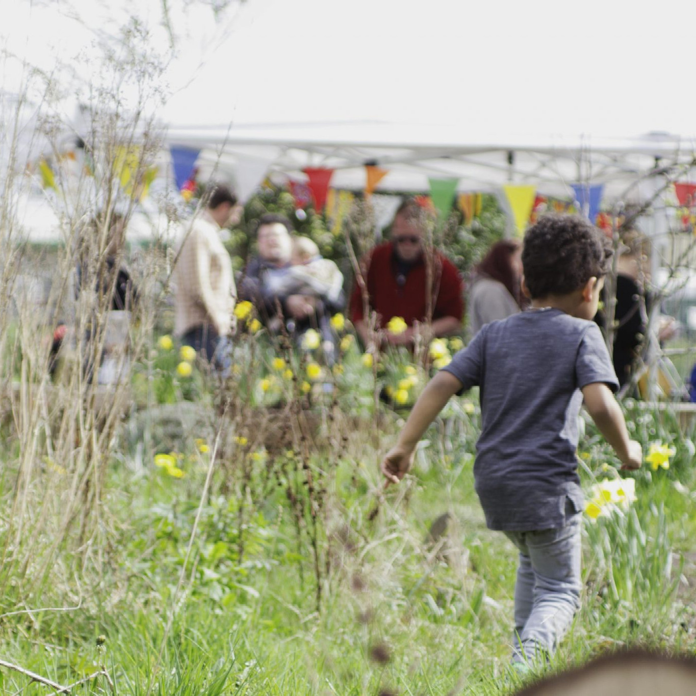 photo of a child playing in the grass at a community event