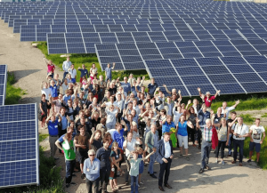 A photo of people standing in front of a solar farm