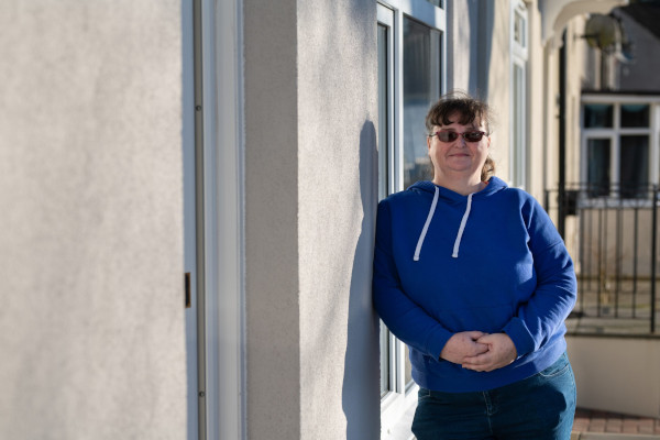 A woman in a blue hoody admiring her new external wall insulation
