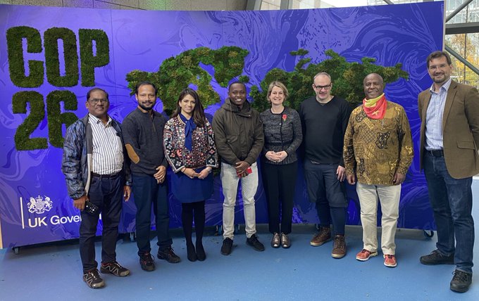 Photo of the 2021 Ashden Award winners in front of a COP26 sign in Glasgow