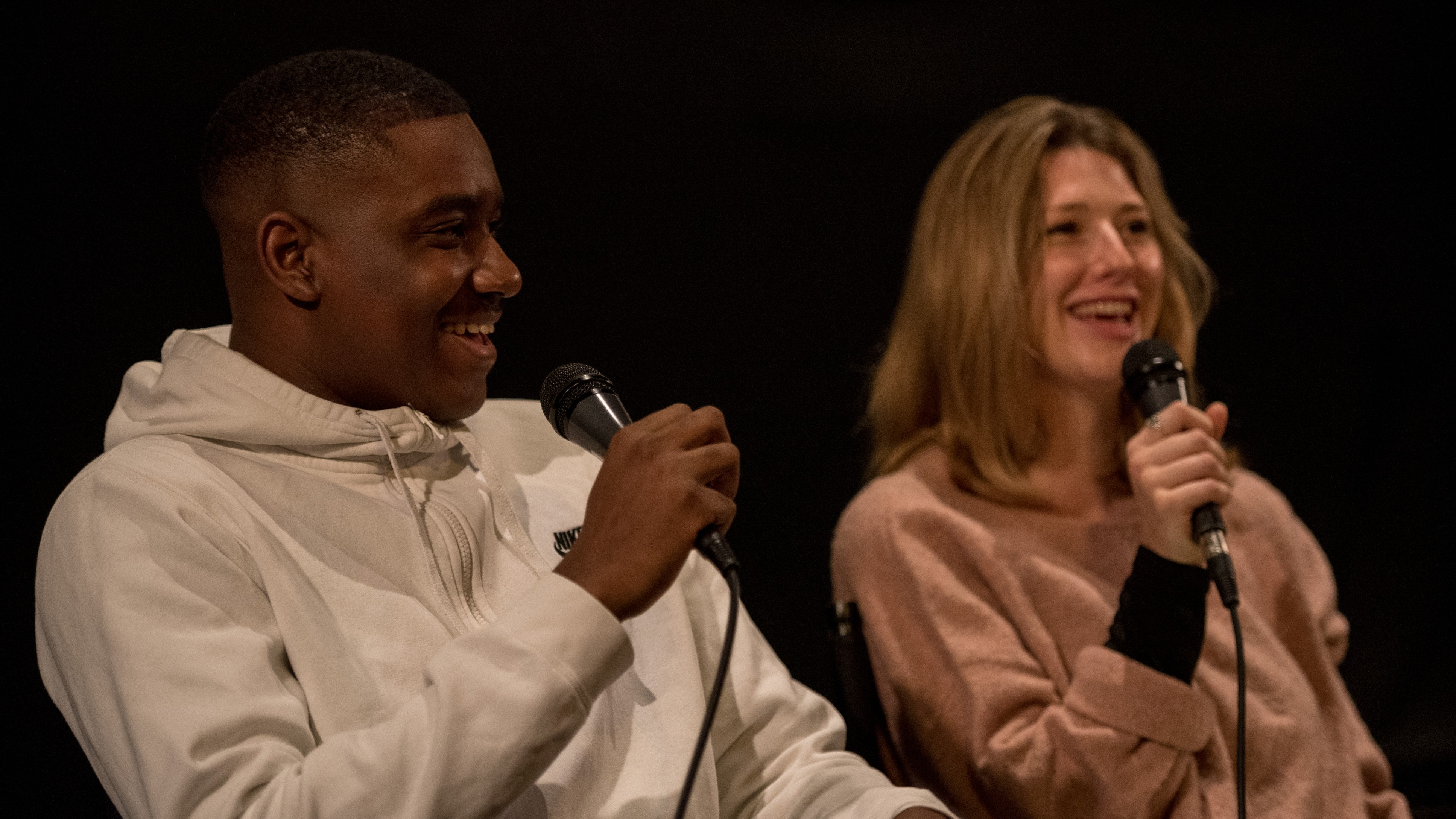 two smiling young people sitting