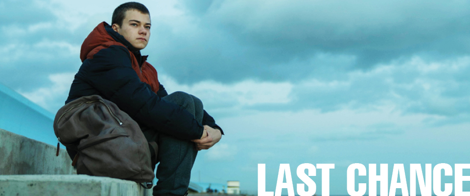 boy with a rucksack sitting on a concrete step