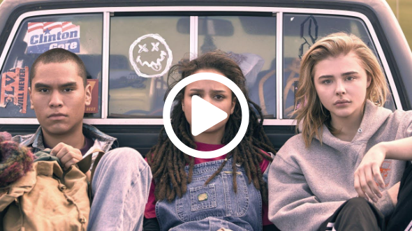 Three young people sitting in the back of a truck