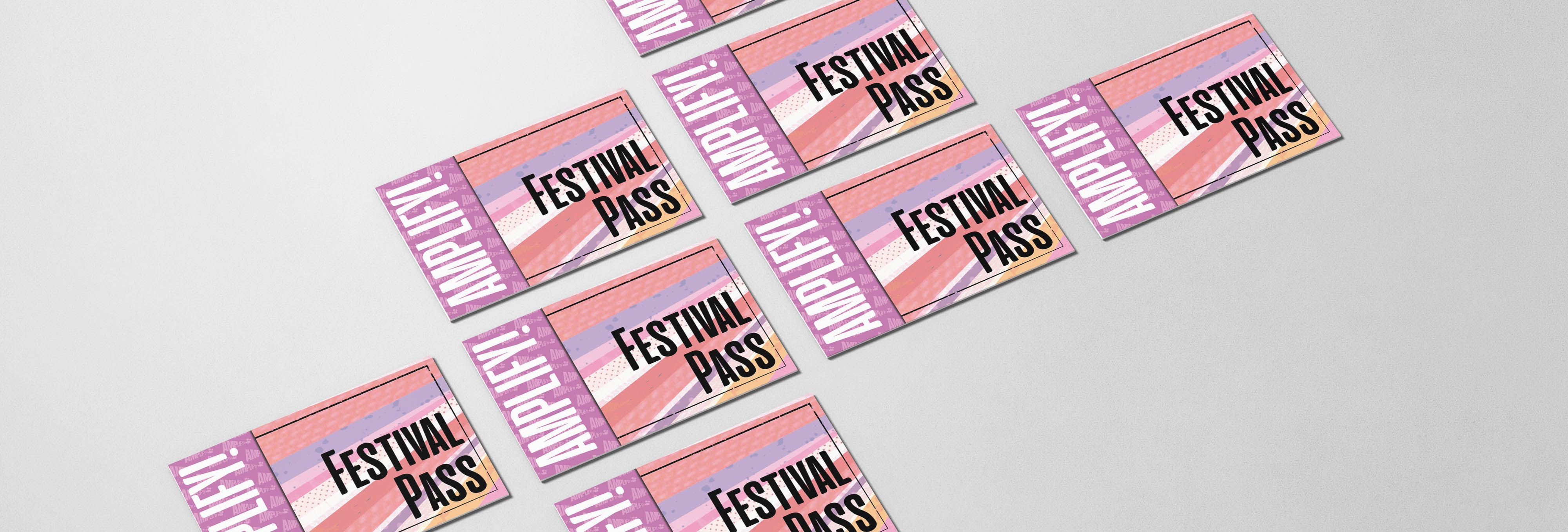 Amplify festival passes laid out on grey background