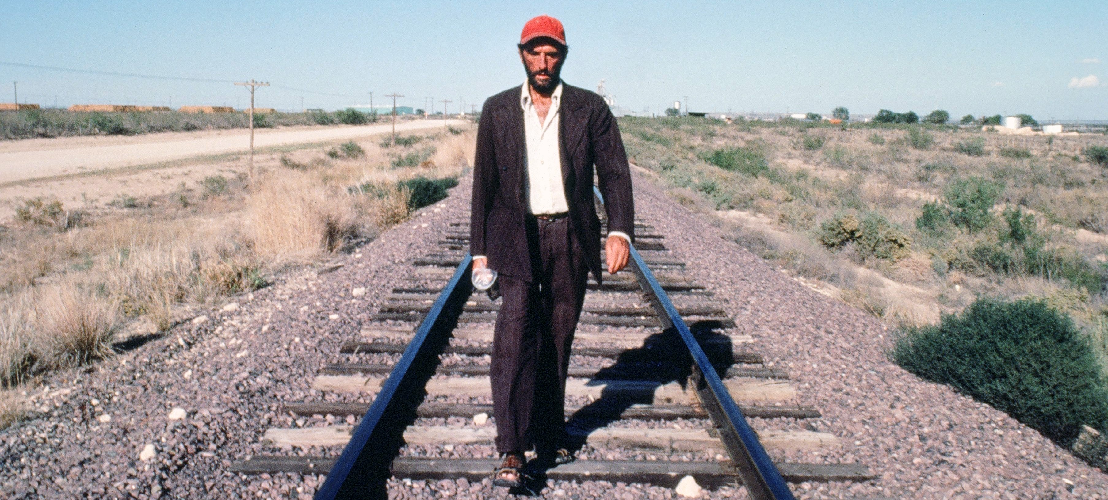 man walking along a railway line