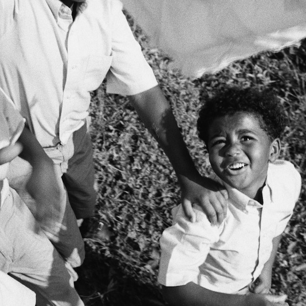 black and white photo of a young boy in a white shirt