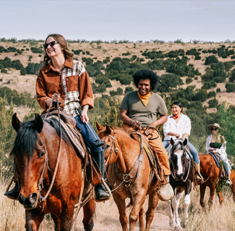 A group touring Palo Duro Canyon on horseback.